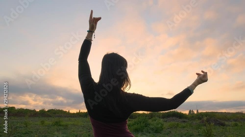 Happy female dance in the summer fields during beautiful sunset 