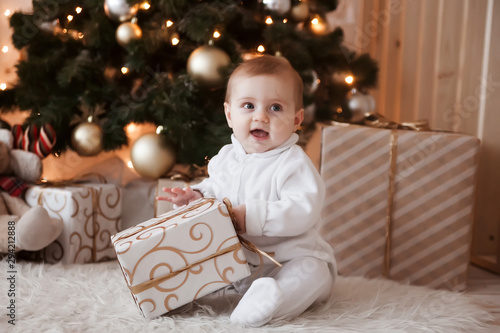 Cute kid with gift at Christmas tree.