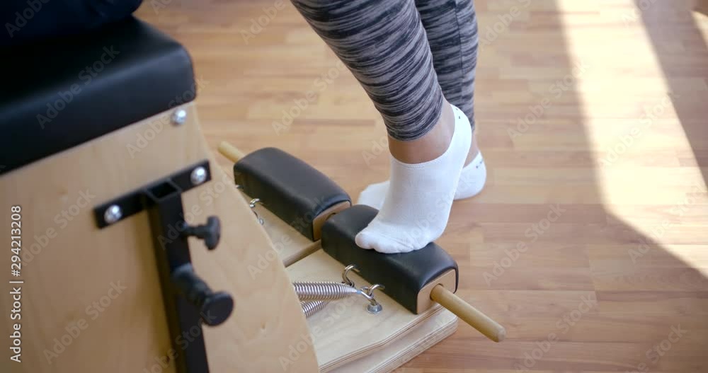 woman in socks and leggings trains on black brown machine woman in socks and leggings trains on black brown machine