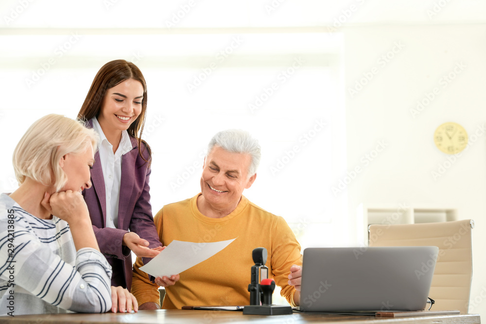 Female notary working with mature couple in office Female notary working with mature couple in office