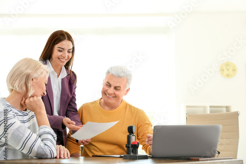 Female notary working with mature couple in office