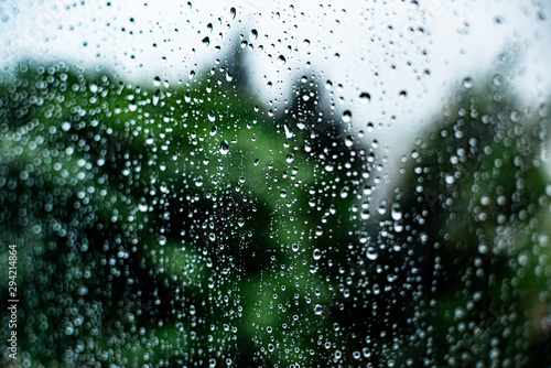 raindrops on the glass outside the window cloudy sky and greenery