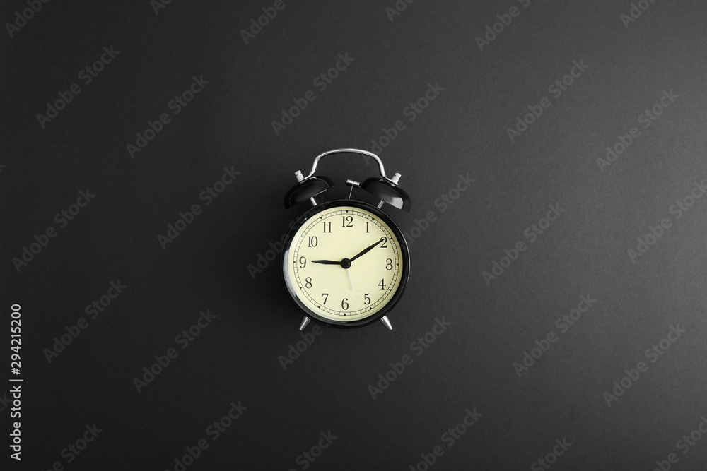 Modern alarm clock on black background, top view Modern alarm clock on black background, top view