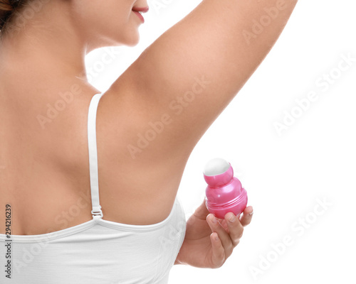 Young woman applying deodorant to armpit on white background, closeup