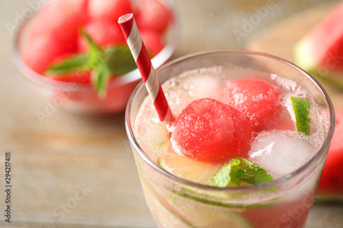 Glass of refreshing watermelon drink on wooden table, closeup