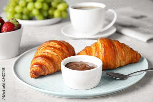 Delicious breakfast with croissants and chocolate served on light table