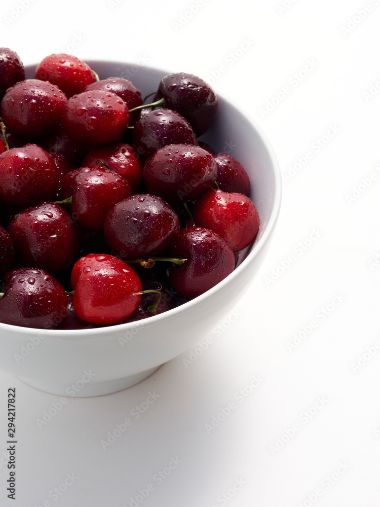 A bowl full of freshly washed cherries on white. A bowl full of freshly washed cherries on white.
