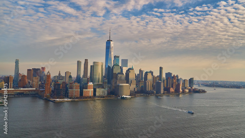 Aerial view of lower Manhattan financial district with modern architecture office buildings shot from helicopter at golden hour 