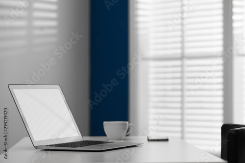 Comfortable workplace with modern laptop on desk in home office, space for text