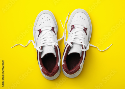 Pair of stylish shoes on yellow background, top view