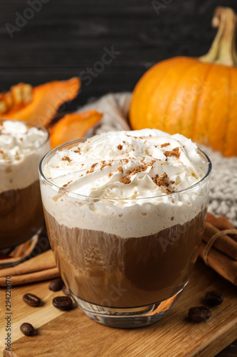 Glass with tasty pumpkin spice latte on wooden table