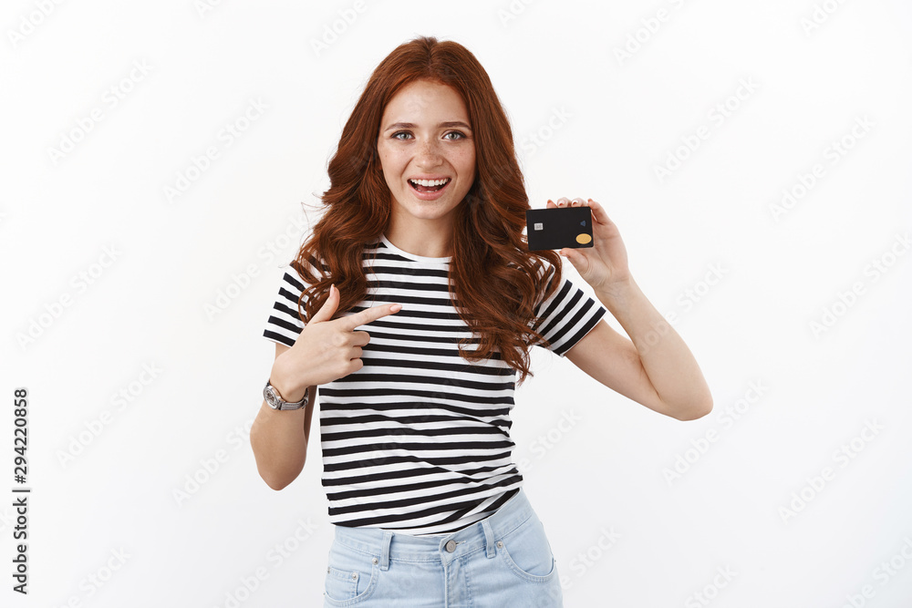 Youth, finance and banking concept. Cheerful ambitious cute redhead female student in striped t-shirt introduce black credit card, open new bank account, satitsfied with cool offers and cashback Youth, finance and banking concept. Cheerful ambitious cute redhead female student in striped t-shirt introduce black credit card, open new bank account, satitsfied with cool offers and cashback