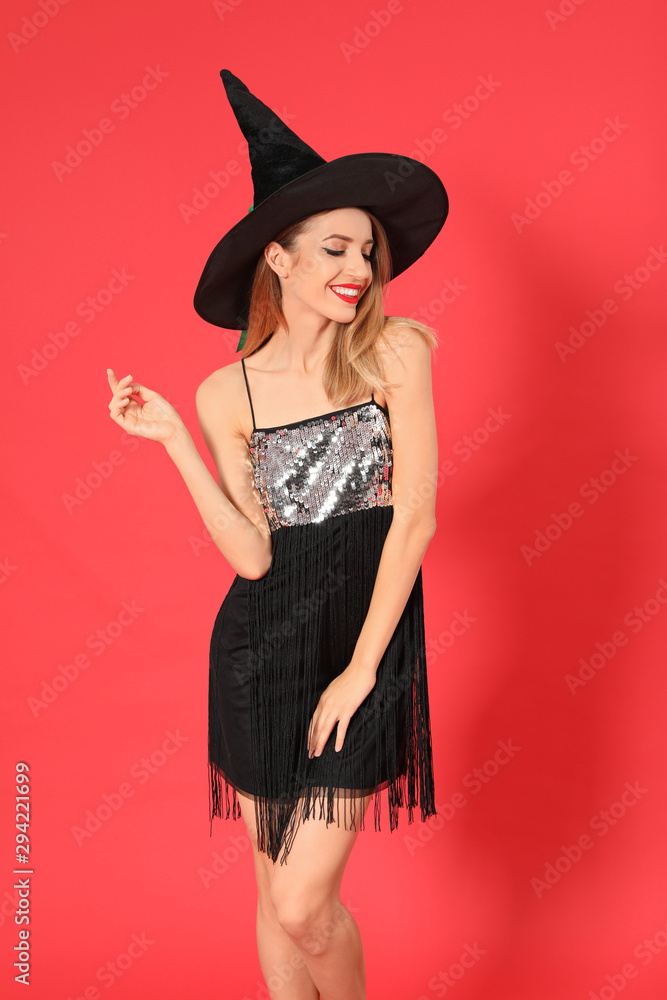 Beautiful young woman wearing witch costume for Halloween party on red background Beautiful young woman wearing witch costume for Halloween party on red background