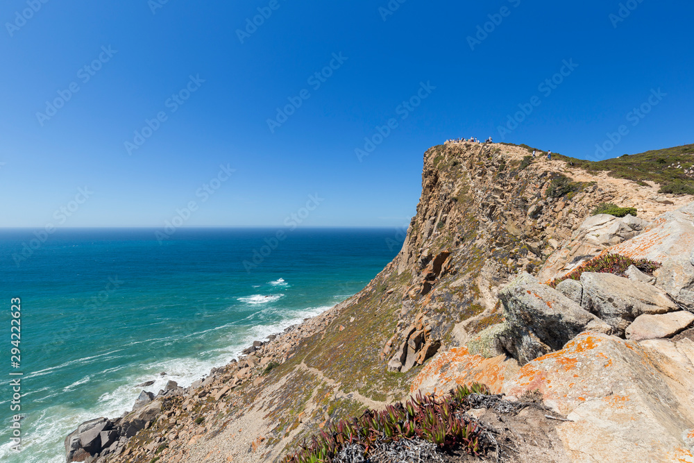 Scenic view of Atlantic Ocean and rugged hill and coast at Cabo da Roca, the westernmost point of continental Europe, in Portugal, on a sunny day.