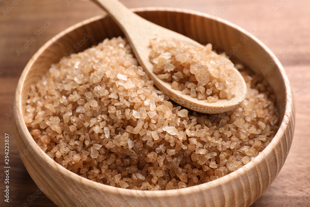 Bowl and spoon with brown sea salt on wooden table, closeup. Spa treatment Bowl and spoon with brown sea salt on wooden table, closeup. Spa treatment