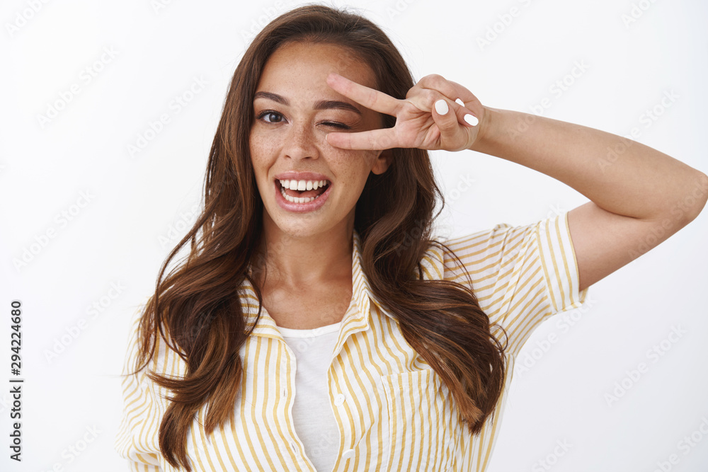 Close-up cheerful upbeat female express goodwill and positivity, feeling excellent after trying new product, smiling toothy satisfactory, wink playful, showing peace, victory sign, white background Close-up cheerful upbeat female express goodwill and positivity, feeling excellent after trying new product, smiling toothy satisfactory, wink playful, showing peace, victory sign, white background
