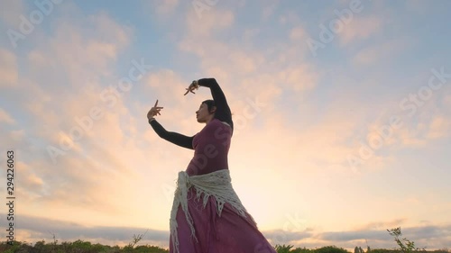 Happy female dance in the summer fields during beautiful sunset 