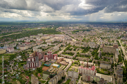 Aerial view of town or city with rows of buildings and curvy streets in summer. Urban landscape from above.