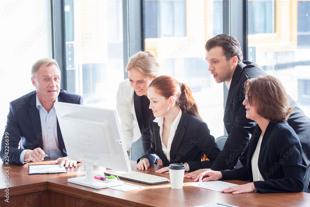 Business team look at one computer monitor Business team look at one computer monitor