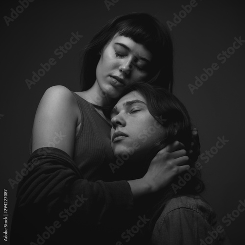 Young caucasian couple in love  on black background. Black and white