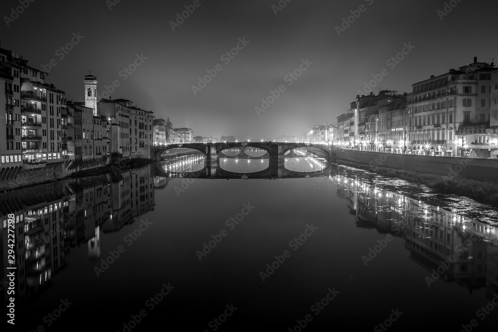 Night view of the Arno river from the famous Ponte Vecchio. Florence, Tuscany, Italy