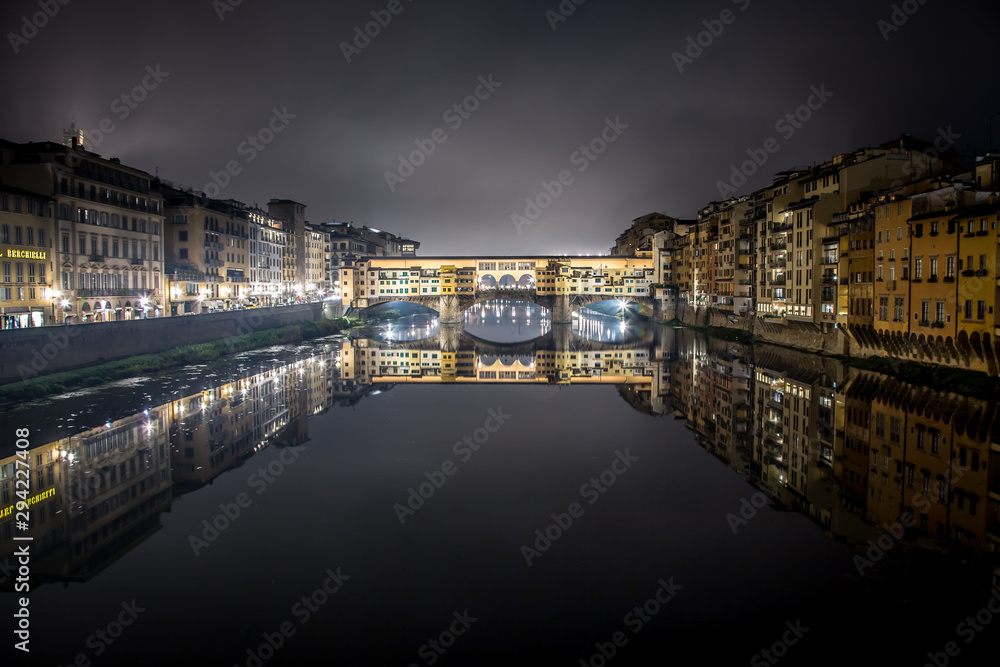Night view of the Arno river and the famous Ponte Vecchio. Florence, Tuscany, Italy