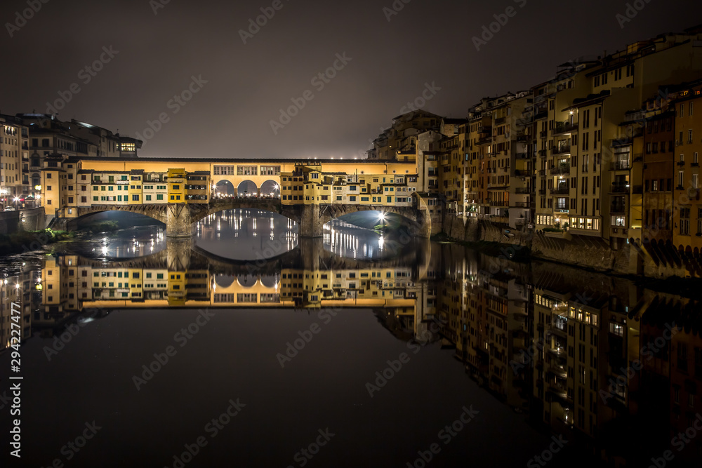 Night view of the Arno river and the famous Ponte Vecchio. Florence, Tuscany, Italy