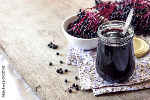 Homemade black elderberry syrup in glass jar photo