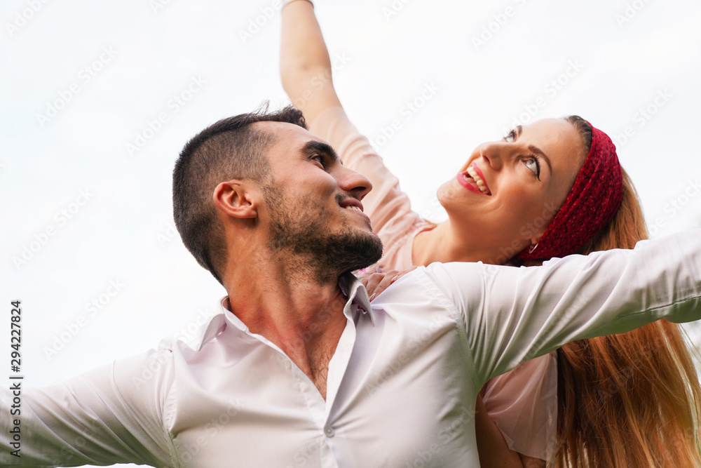 Obraz premium trait of excited funny funky two people look at sky space hold hand near eyes hug piggyback wear stylish trendy clothes. Happy couple piggybacking. 