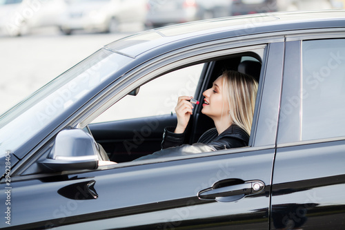 Woman use lipstick inside her new car © Maksymiv Iurii