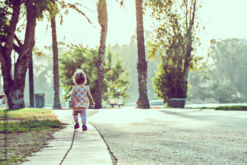 Little girl walking on the road at the park 