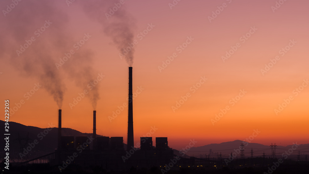 Dark smoke from the chimneys of a thermal power plant. A type of power plant that uses coal to generate electricity. Coal is a fossil fuel that is bad for the environment. Sunset. Dark smoke from the chimneys of a thermal power plant. A type of power plant that uses coal to generate electricity. Coal is a fossil fuel that is bad for the environment. Sunset.