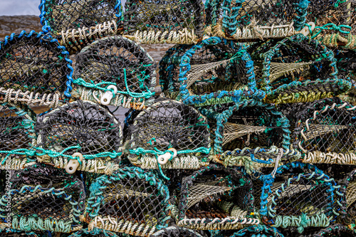 Lobster pots stacked on top of each other at a harbour in the Western Isles