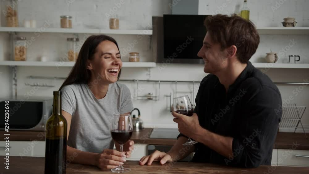 a young couple communicates on a date and talks about each other. Slowly drinking wine in the kitchen. a young couple communicates on a date and talks about each other. Slowly drinking wine in the kitchen.
