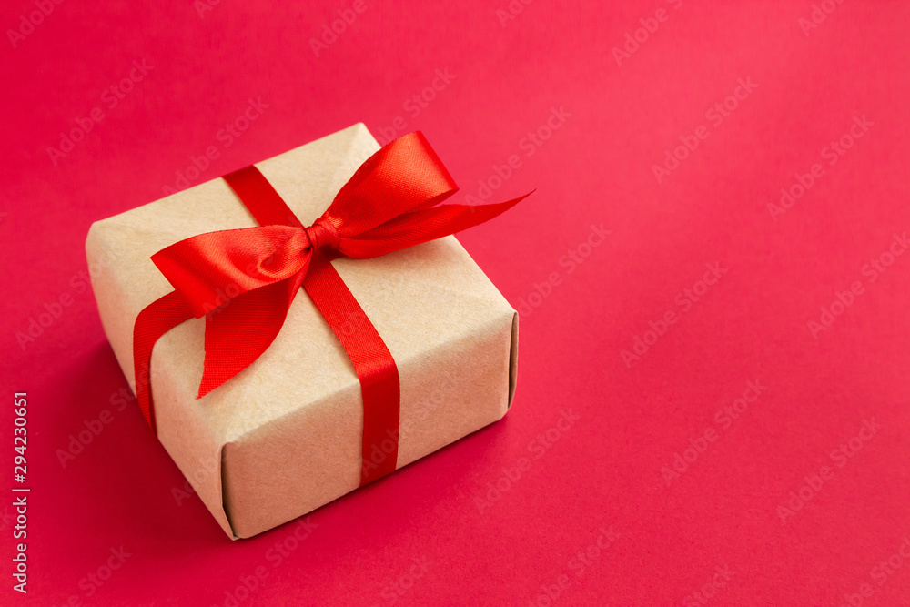brown gift box with red ribbon on red background top view for christmas or celebrate brown gift box with red ribbon on red background top view for christmas or celebrate