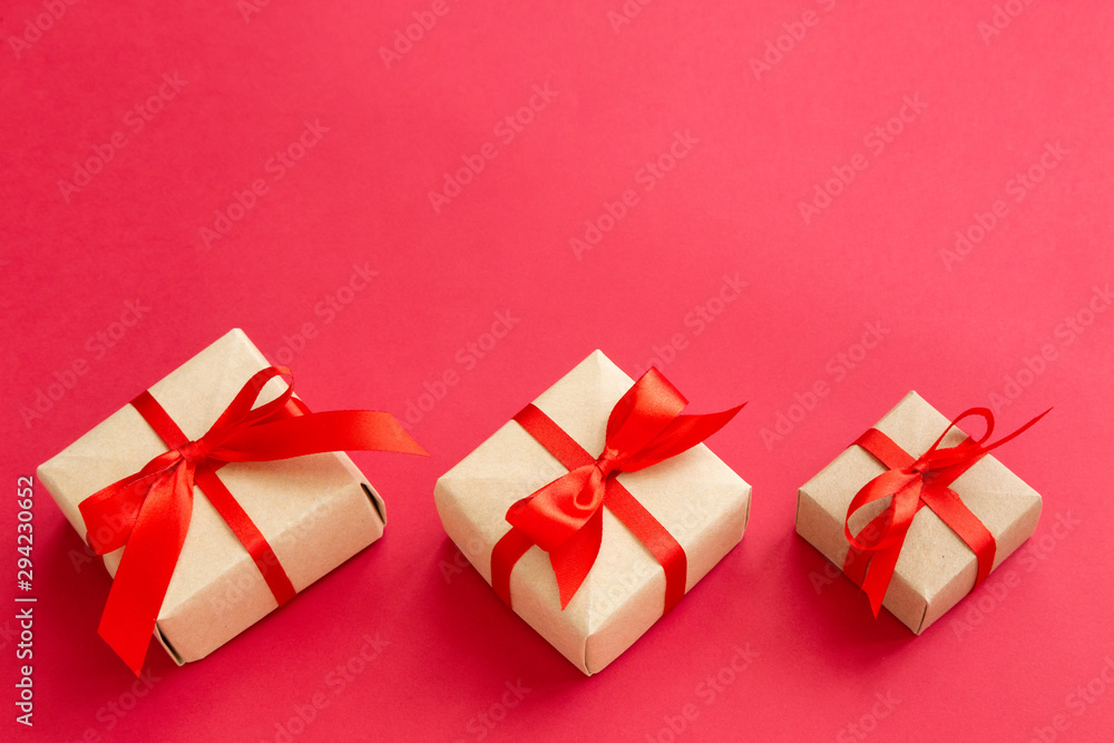 brown gift box with red ribbon on red background top view for christmas or celebrate brown gift box with red ribbon on red background top view for christmas or celebrate