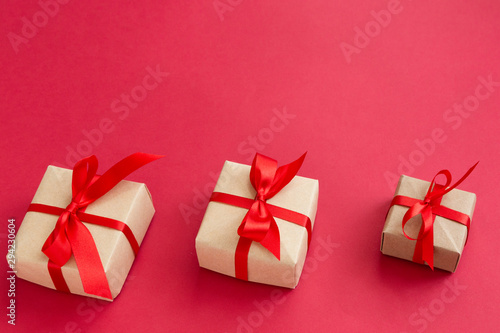 brown gift box with red ribbon on red background top view for christmas or celebrate © sattawat