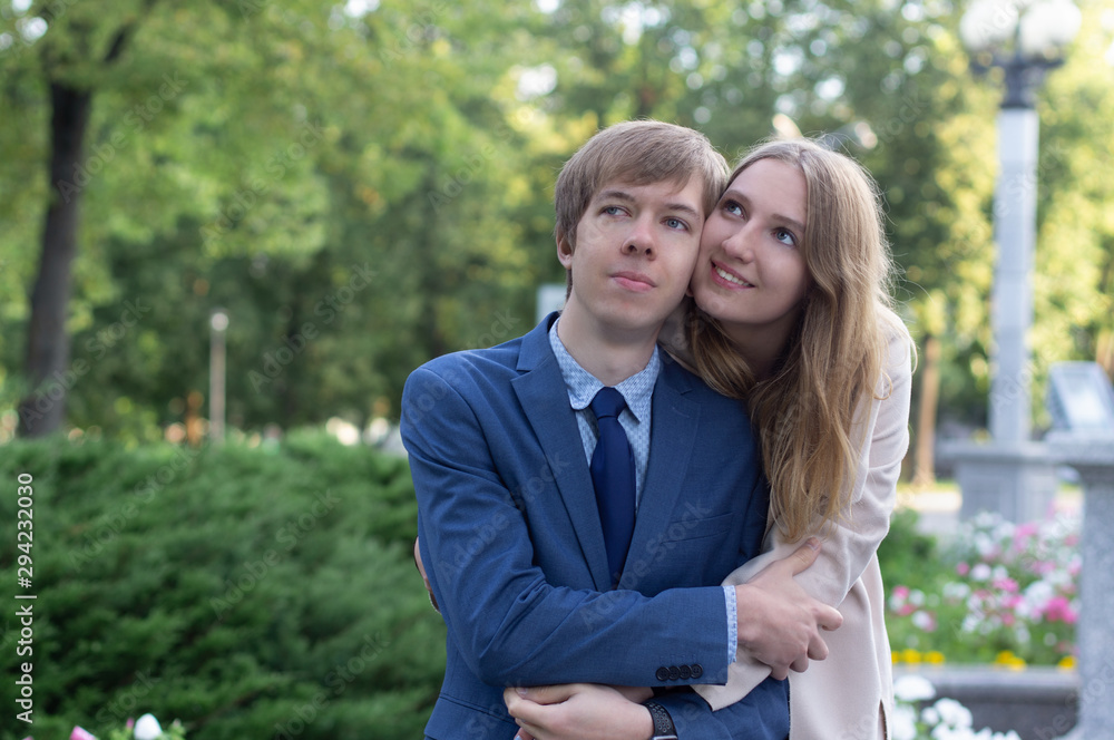 Fototapeta premium Young romantic couple hugging sitting on bench