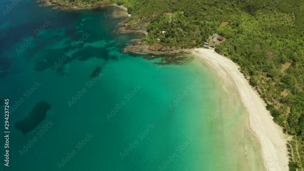 Aerial drone of beautiful tropical beach in cove with blue lagoon and turquoise water. Seascape with sea, sand, palm trees. Nagtabon, Palawan, Philippines. Aerial drone of beautiful tropical beach in cove with blue lagoon and turquoise water. Seascape with sea, sand, palm trees. Nagtabon, Palawan, Philippines.