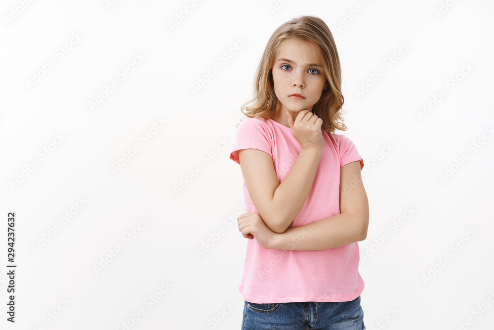Smart good-looking clever little blong girl look serious and focused, carefully listen teacher, attend drama classes, making determined strict expression, touch chin thoughtful, white background Smart good-looking clever little blong girl look serious and focused, carefully listen teacher, attend drama classes, making determined strict expression, touch chin thoughtful, white background