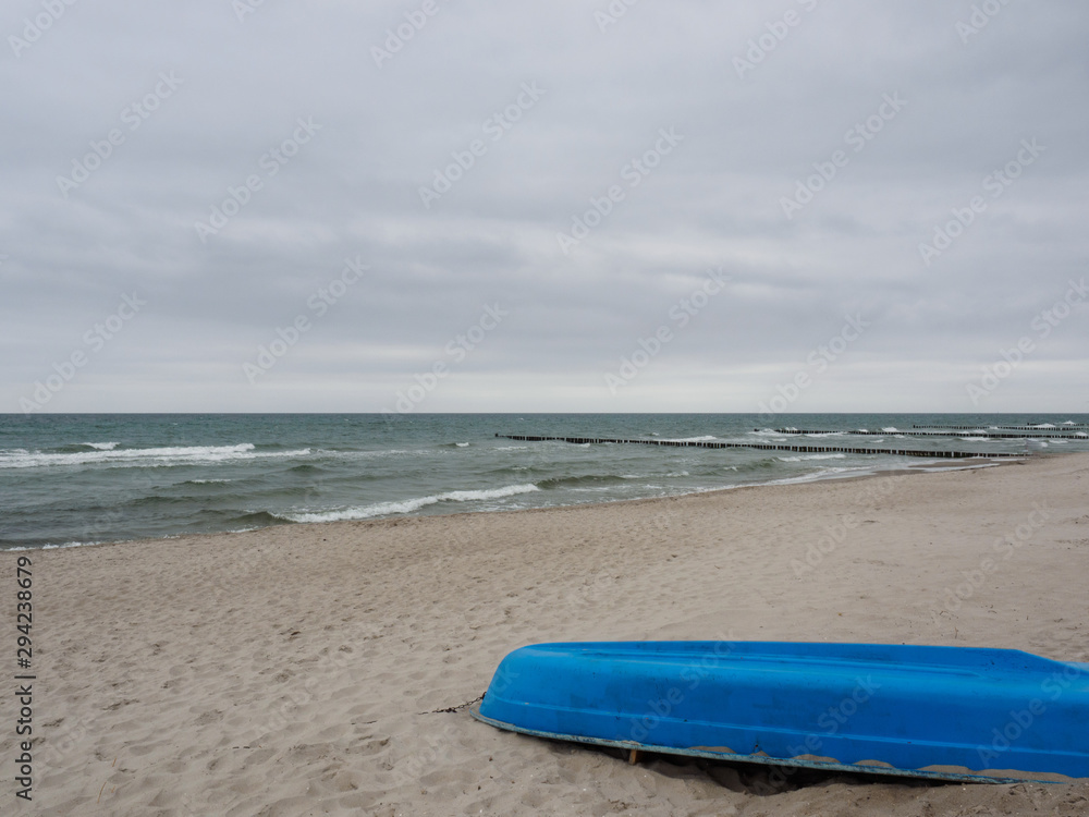 Blaues Boot am Strand an einem trüben Tag Blaues Boot am Strand an einem trüben Tag