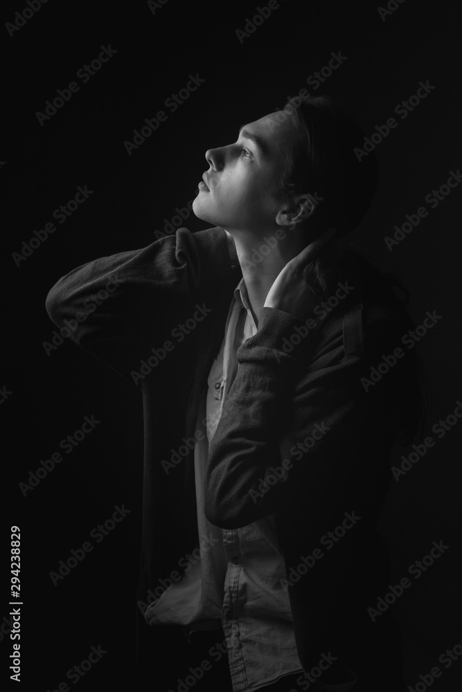 Portrait of young man in studio. Black and white. Profile