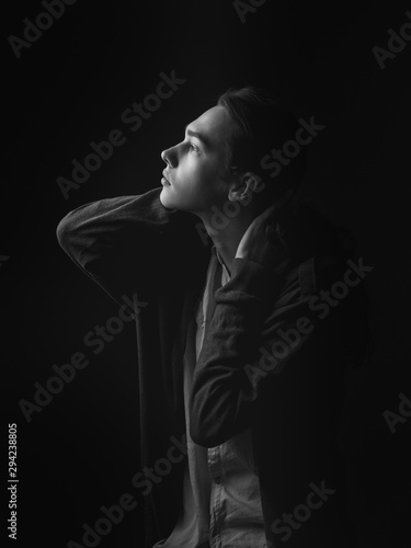 Portrait of young man in studio. Black and white. Profile