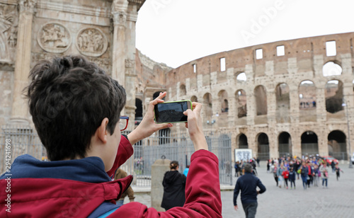 boy photographs the Colosseum in Rome photo