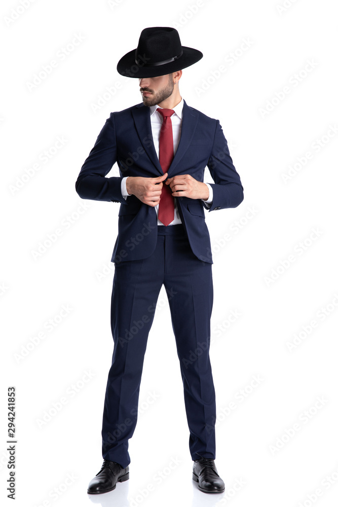 Tough businessman unbuttoning his shirt and looking to the side