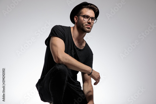 casual man standing crouched and looking away pensive