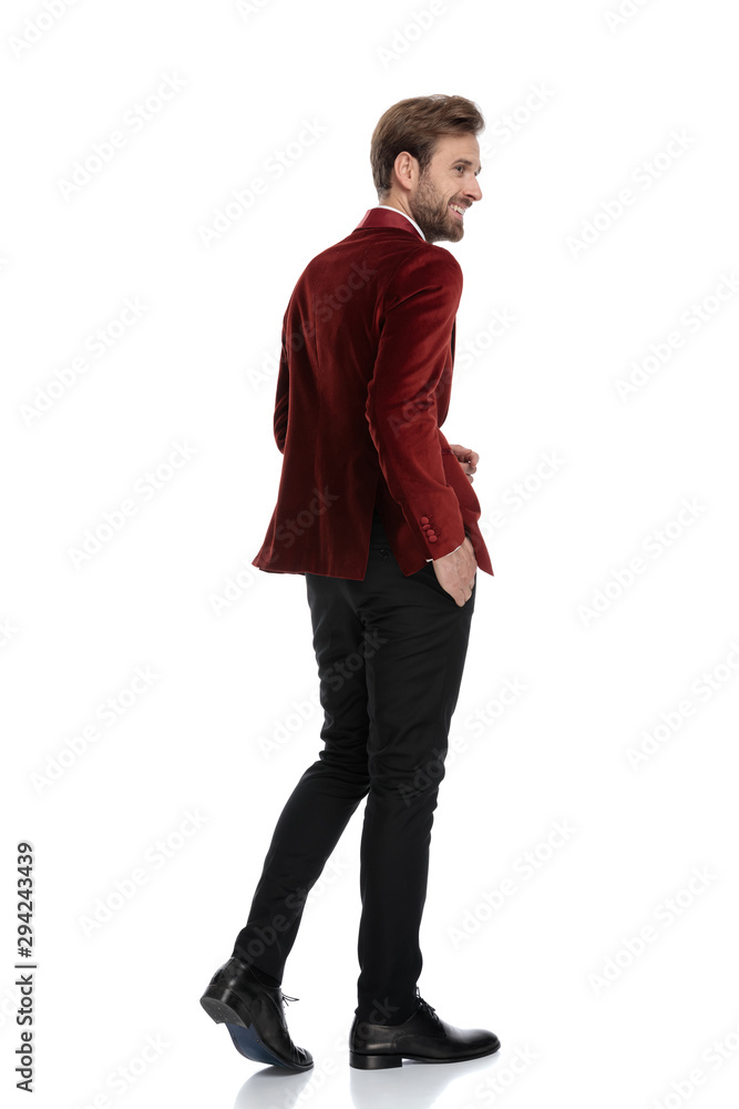 Fototapeta premium smiling groom wearing red velvet tuxedo and walking