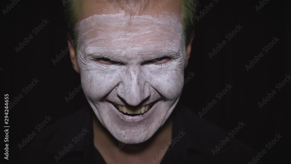 Clown Halloween man portrait. Close-up of an evil clowns face. White face makeup Clown Halloween man portrait. Close-up of an evil clowns face. White face makeup