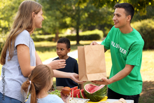 Young volunteer giving food...