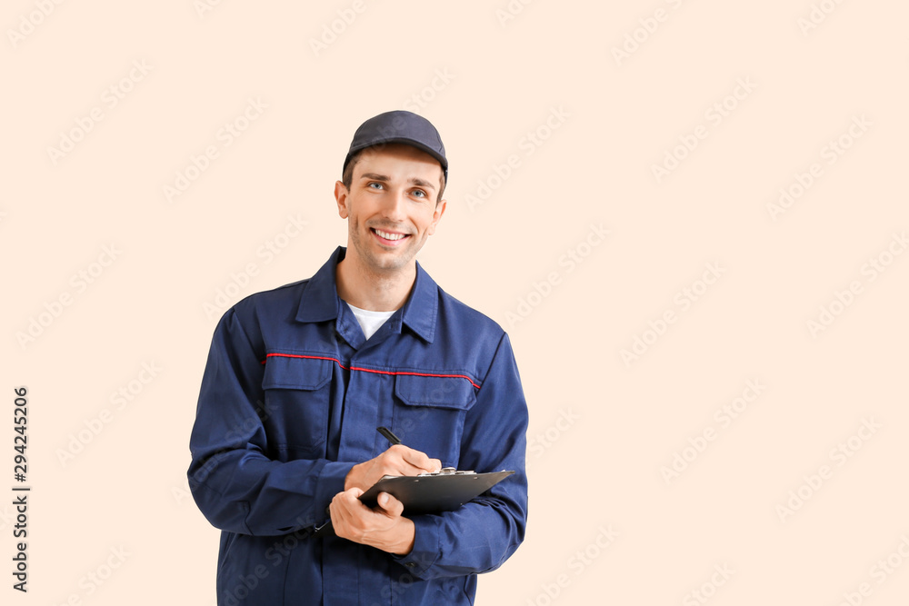 Male car mechanic with clipboard on color background Male car mechanic with clipboard on color background